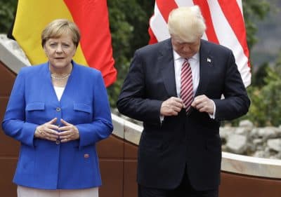 U.S. President Donald Trump, right, adjusts his jacket as he stands with German Chancellor Angela Merkel prior to a group photo during a G7 Summit in Taormina, Italy, Friday, May 26, 2017. (Andrew Medichini/AP)