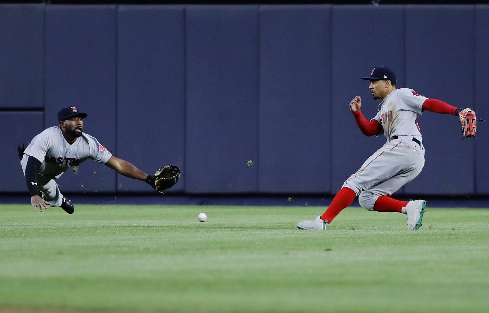 Boston Red Sox center fielder Jackie Bradley Jr., left, dives to catch a ball hit by New York Yankees' Didi Gregorius for a single as right fielder Mookie Betts, right, watches during the second inning of a baseball game Thursday, June 8, 2017, in New York. (AP Photo/Frank Franklin II)
