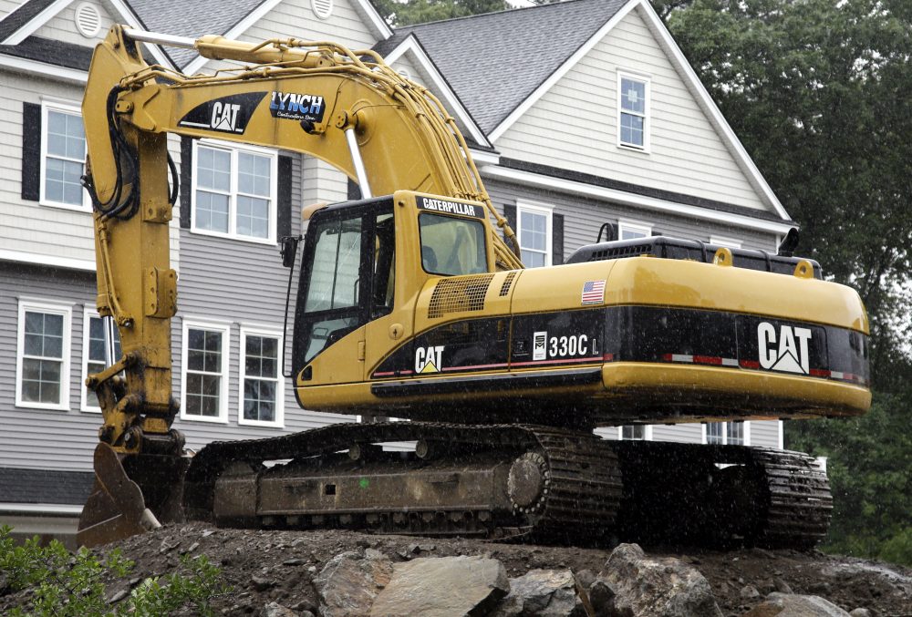 In this July 24, 2017, photo, a Caterpillar excavator rests at a housing construction site in North Andover, Mass. (AP Photo/Elise Amendola)