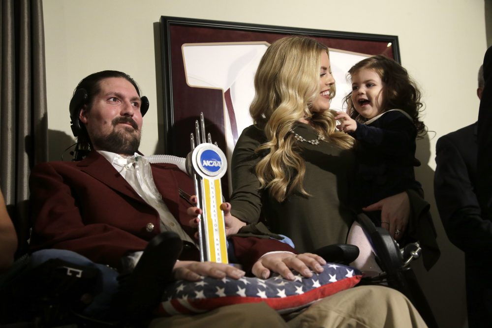 Pete Frates appears with his wife Julie and their 2-year-old daughter Lucy moments after he was presented with the 2017 NCAA Inspiration Award, on Dec. 13, 2016, at their home in Beverly. (Steven Senne/AP)