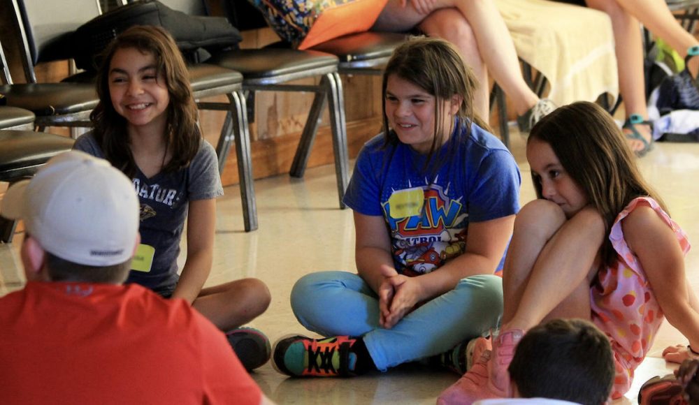 Alissa Scott, left, sits with other campers during a music session at Camp Evergreen. The three-day camp is designed to help children manage the mourning process. (Teri Nine/Alive Hospice)