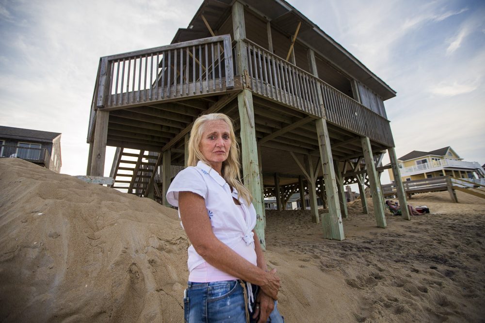 Freve Pace stands in front of the house she once owned but had to sell because of the repeated storm damage and erosion of the beach. When she bought it in the 1990s, says says, &quot;There was a dune in front of it. We couldn't see the sea. It became clear we had to sell. I am still sad about it.&quot; (Jesse Costa/WBUR)