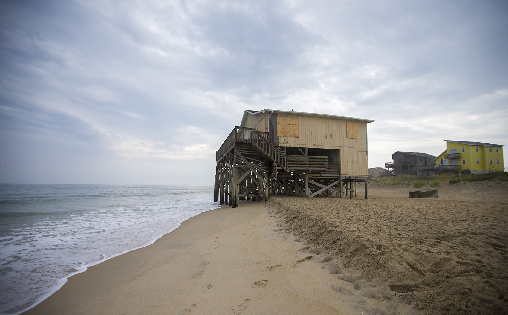 The Atlantic Ocean laps at the feet of a condemned house on Seagull Drive on Nags Head Beach on North Carolina's Outer Banks. The house was part of a larger development of houses that have either been moved or have succumbed to the ocean. (Jesse Costa/WBUR)