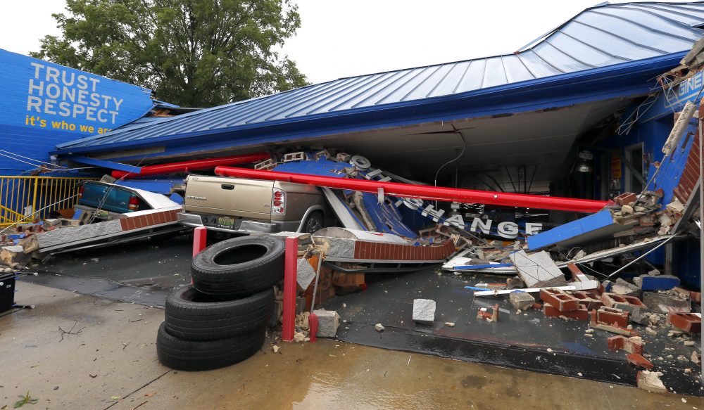 Several cars sit under the collapsed roof of an Express Oil Change after a possible tornado touched down destroying several businesses, June 22, 2017, in Fairfield, Ala. (Butch Dill/AP)