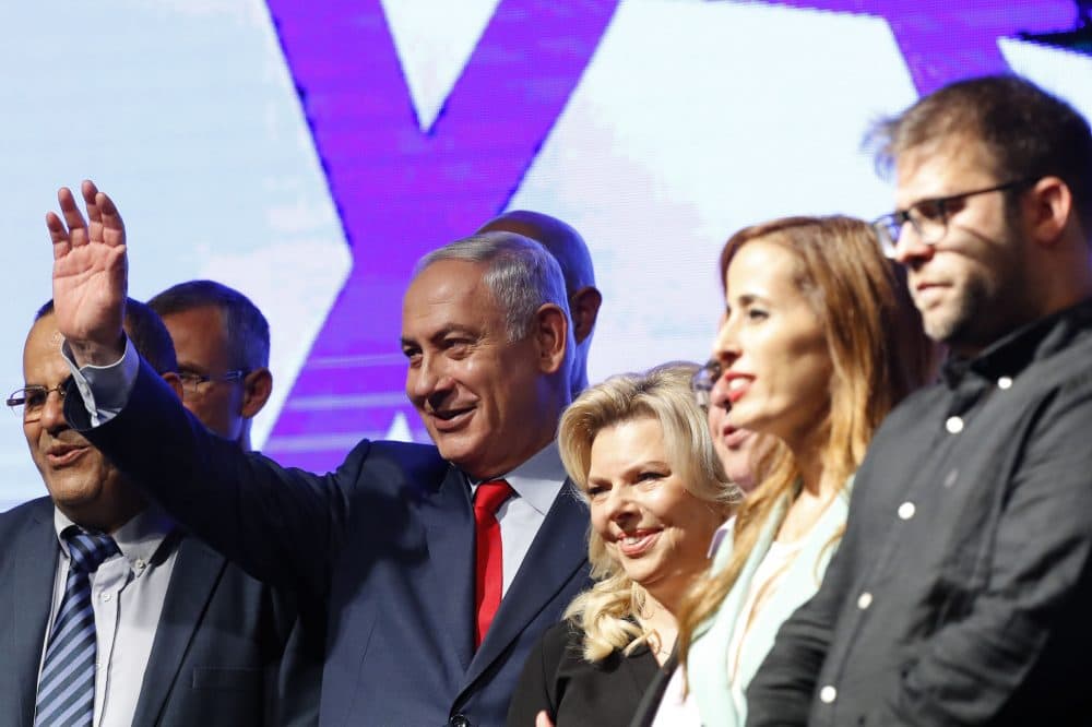 Israeli Prime Minister Benjamin Netanyahu (second from left) and his wife Sara (center) react during a gathering by Likud party members and activists at the Tel Aviv Convention Center on Aug. 9, 2017 in a mass show of support for the prime minister, who is facing a string of corruption investigations. (Jack Guez/AFP/Getty Images)