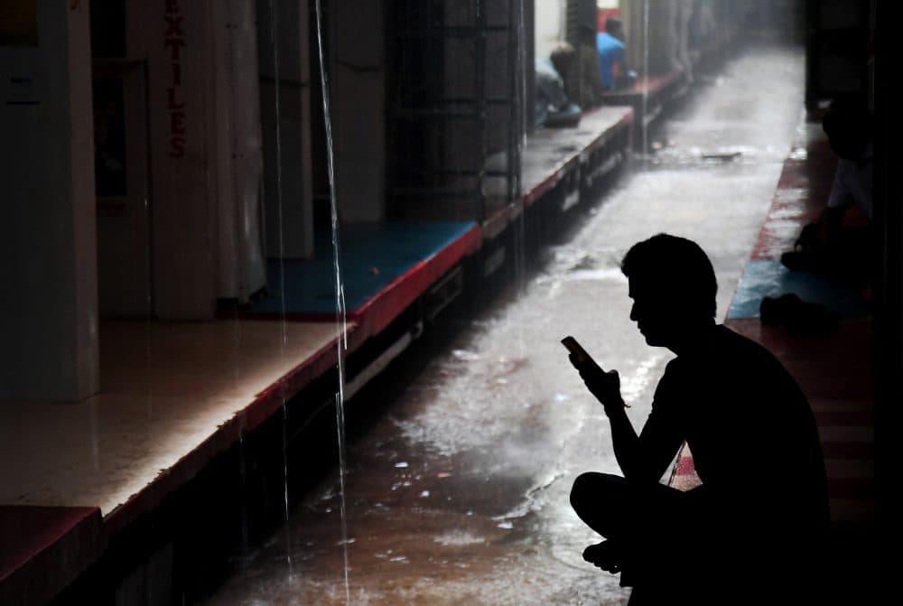 An Indian textile trader looks at his phone in Kolkata on June 30, 2017. (Dibyangshu Sarkar/AFP/Getty Images)