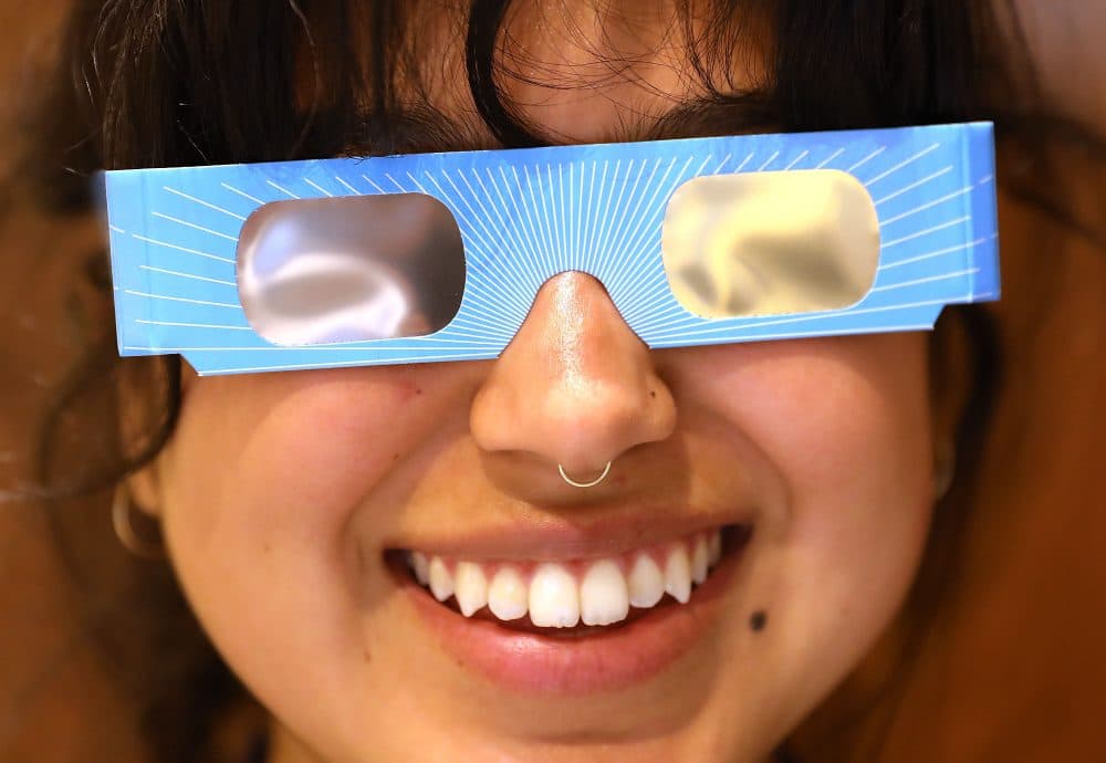 Warby Parker employee Karolyna Landin poses with a pair of solar eclipse glasses that the eyeglass store is giving out for free on Aug. 11, 2017 in New York City. To view the upcoming total solar eclipse on Aug. 21, eye protection is essential. (Spencer Platt/Getty Images)