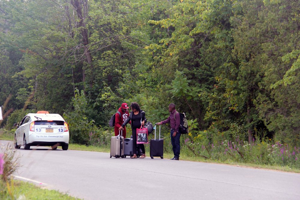 Three people from Haiti make their way to the Roxham Road crossing in a taxi. One of the young men had been living in San Diego for over a year, but is looking for asylum in Canada. (Kathleen Masterson/VPR) 
