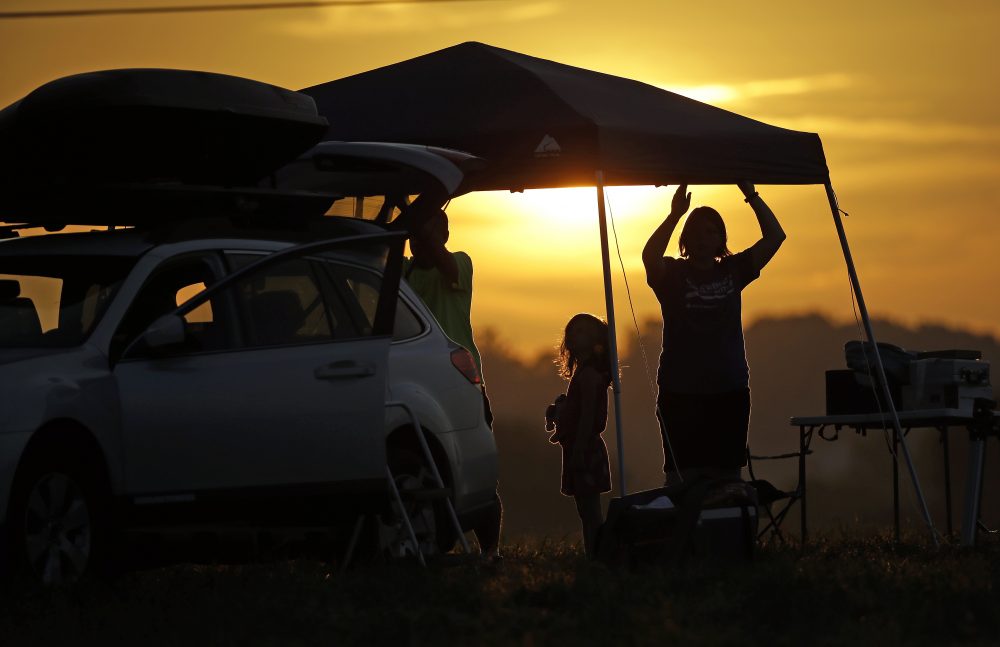 A family sets up a tent at their campsite at sunrise for the solar eclipse Monday, Aug. 21, 2017, on the Orchard Dale historical farm near Hopkinsville, Ky. The location, which is in the path of totality, is also at the point of greatest intensity. (Mark Humphrey/AP)