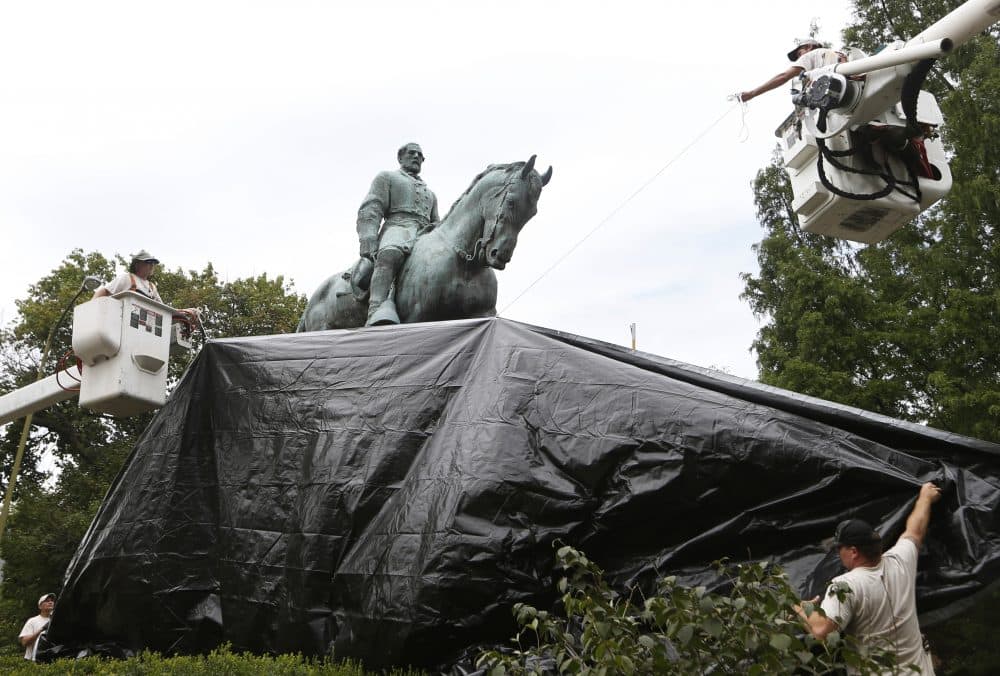 City workers drape a tarp over the statue of Confederate General Robert E. Lee in Emancipation park in Charlottesville, Va., Wednesday, Aug. 23, 2017. (Steve Helber/AP)