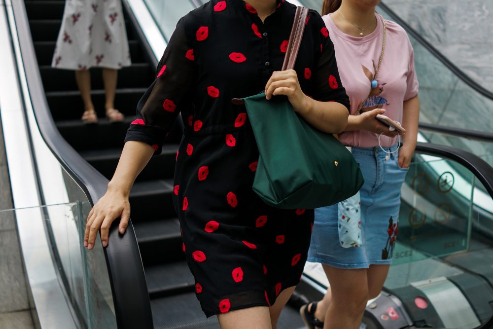 Chinese women descend from an escalator in the Lujiazui Financial District in Pudong in Shanghai, on Aug. 1, 2017. (Chandan Khanna/AFP/Getty Images)