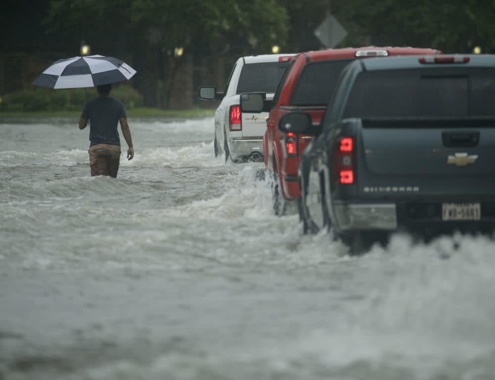 A pedestrian crosses a street inundated by floodwaters from Tropical Storm Harvey on Sunday in Houston. (Charlie Riedel/AP)