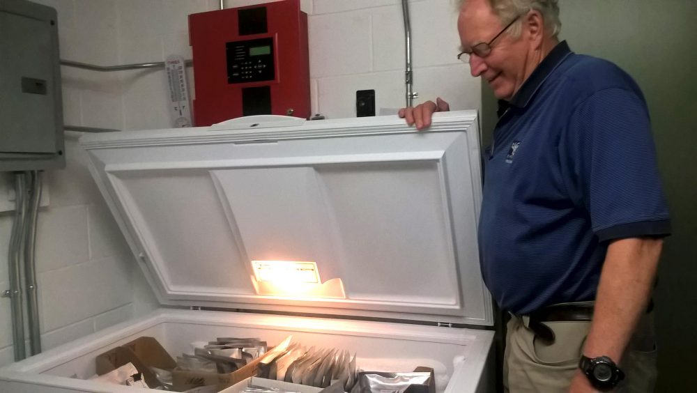 New England Wildflower Society's Bill Brumback, opening the freezer that acts as the &quot;seed vault,&quot; in Framingham, Mass. (Jill Kaufman/NEPR)