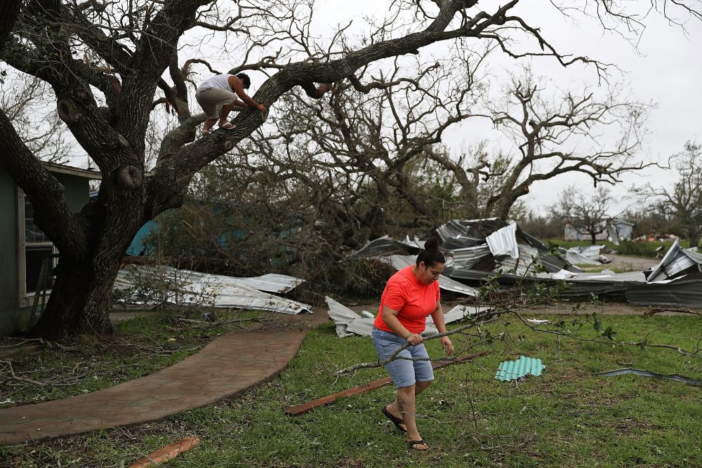 Joshua Nguyen (left) and Deserae Garcia clean up around their home after Hurricane Harvey passed through on Aug. 27, 2017 in Rockport, Texas. (Joe Raedle/Getty Images)