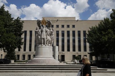 A woman walks past the George Gordon Meade Memorial in front of the E. Barrett Prettyman Federal Courthouse, Aug. 10, 2017, in Washington, where the Trump grand jury will meet. (Jacquelyn Martin/AP)