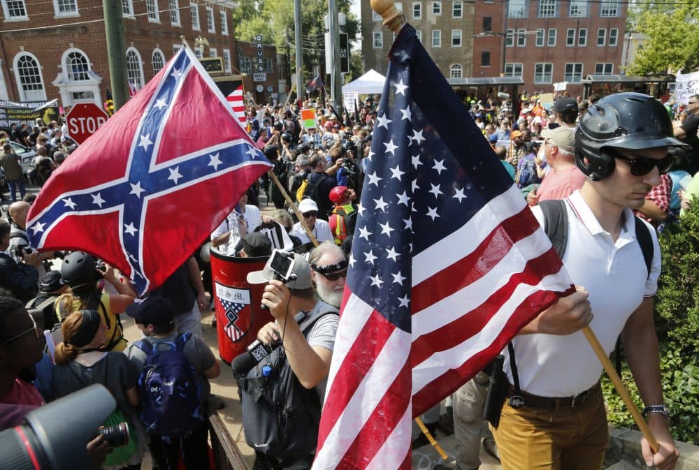 White nationalist demonstrators walk into Lee park surrounded by counter demonstrators in Charlottesville, Va., Saturday, Aug. 12, 2017. (Steve Helber/AP)