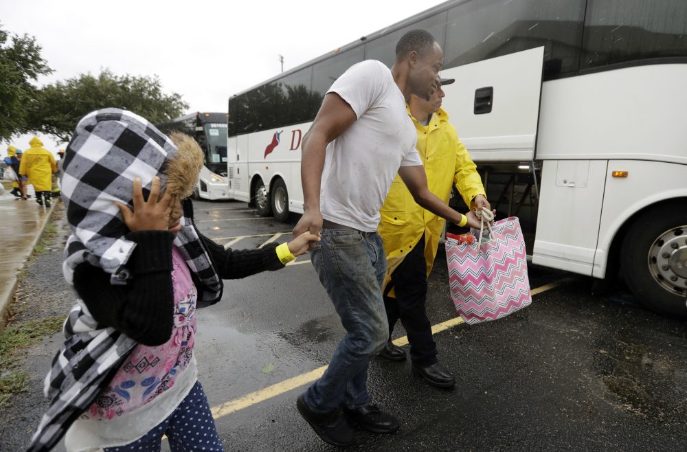 A family is helped to a bus as they are evacuated as the outer bands of Hurricane Harvey begin to make landfall, Friday, Aug. 25, 2017, in Corpus Christi, Texas. Harvey intensified into a hurricane Thursday and steered for the Texas coast with the potential for up to 3 feet of rain, 125 mph winds and 12-foot storm surges in what could be the fiercest hurricane to hit the United States in almost a dozen years.(AP Photo/Eric Gay)