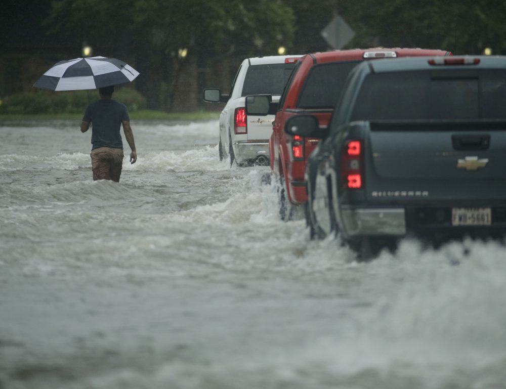 A pedestrian crosses a street inundated by floodwaters from Tropical Storm Harvey on Sunday, Aug. 27, 2017, in Houston, Texas. (Charlie Riedel/AP)