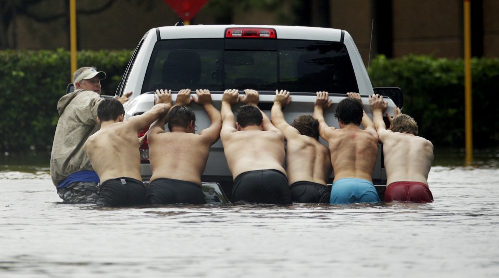 People push a stalled pickup through a flooded street in Houston, after Tropical Storm Harvey dumped heavy rains, Sunday, Aug. 27, 2017. The remnants of Harvey sent devastating floods pouring into Houston on Sunday as rising water chased thousands of people to rooftops or higher ground. (Charlie Riedel/ AP)