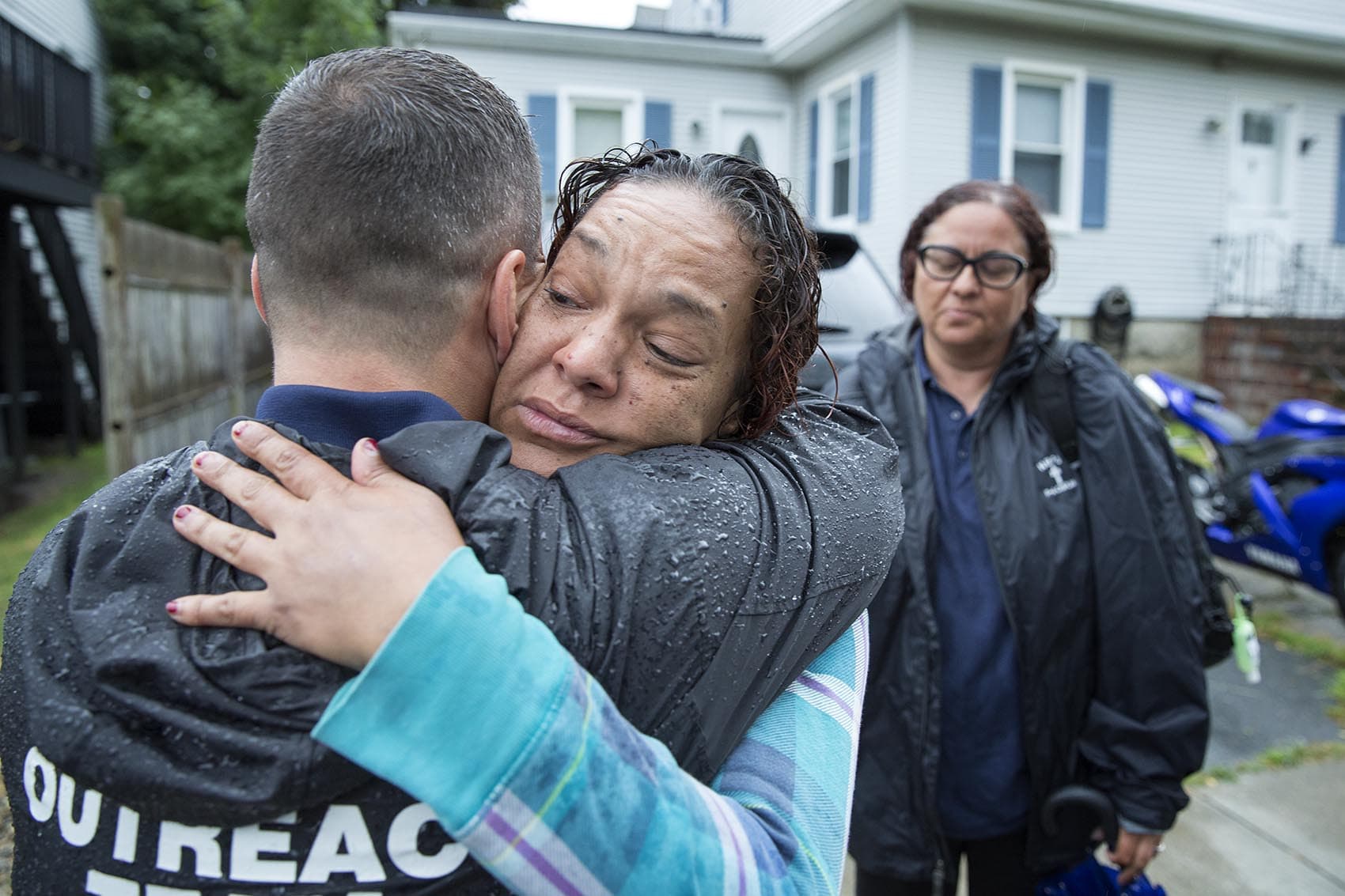 In New Bedford, outreach teams made up of of a police officer, a member of the clergy, and a counselor go out three nights a week looking for people who've recently survived an opioid overdose to try to get them into treatment. Here, Tenelle Pina hugs Pastor Jamie Casey and tells him she's ready to go to detox. (Robin Lubbock/WBUR)
