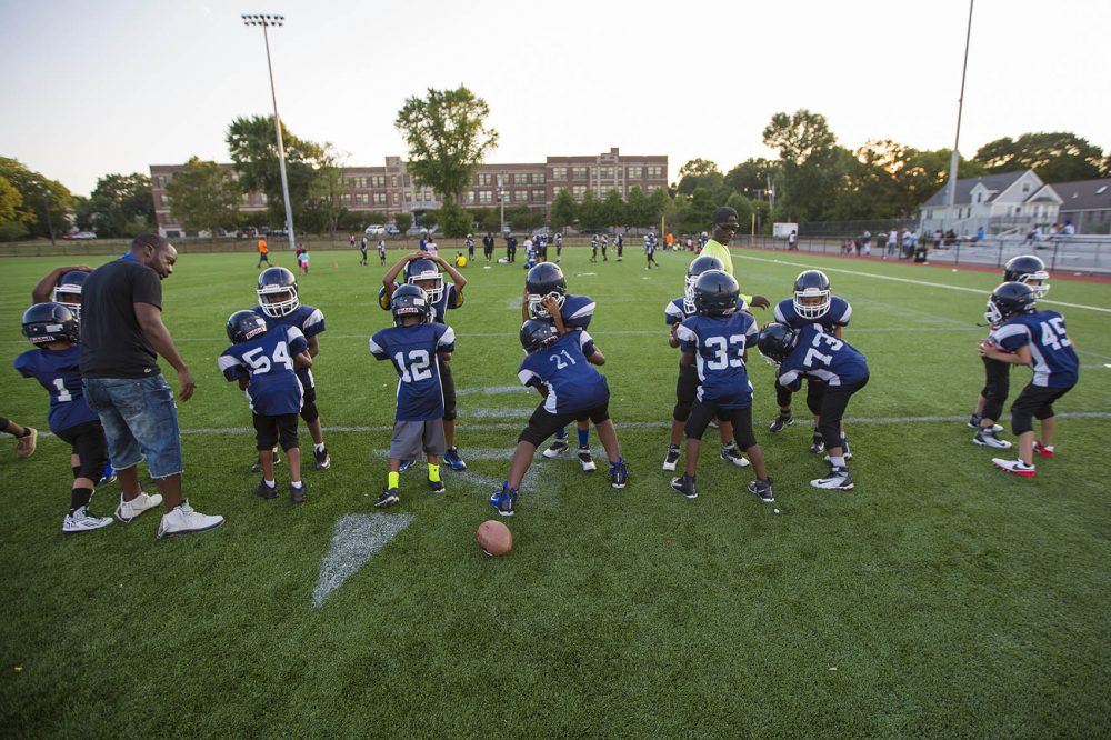 Youth football players of the Dorchester Eagles perform drills during practice in August 2016. (Jesse Costa/WBUR)