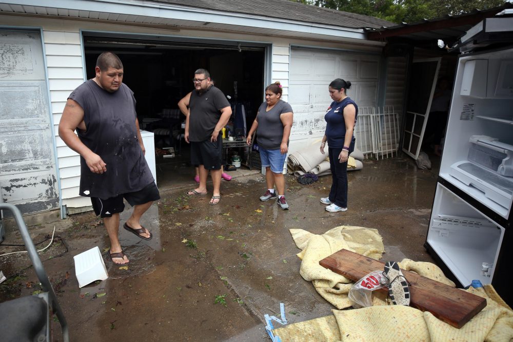 Garcia family members clean out their house and garage Wednesday in East Houston after the floods. (Jorge Sanhueza-Lyon/KUT News)