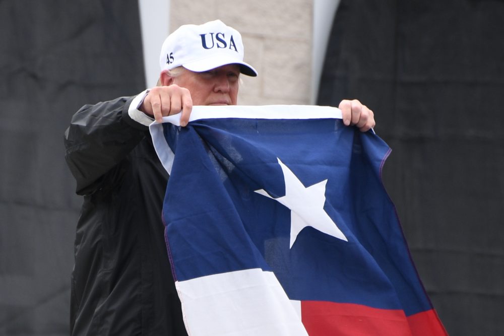 President Trump holds the state flag of Texas outside of the Annaville Fire House after attending a briefing on Hurricane Harvey in Corpus Christi, Texas, on Aug. 29, 2017. (Jim Watson/AFP/Getty Images)