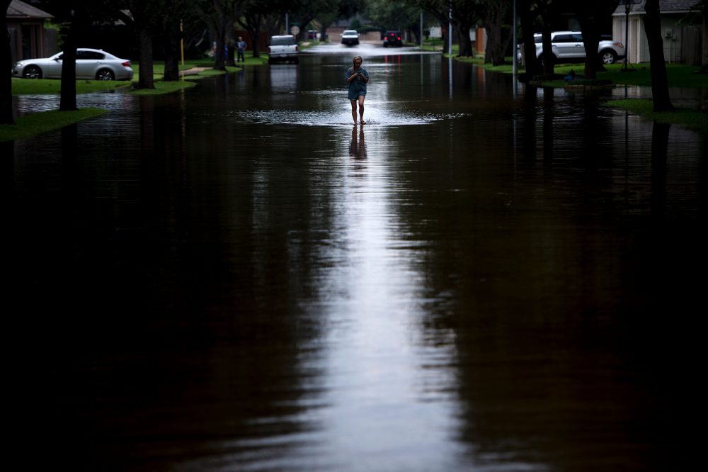 A woman walks down a flooded road during the aftermath of Hurricane Harvey on Aug. 30, 2017 in Houston, Texas. (Brendan Smialowski/AFP/Getty Images)
