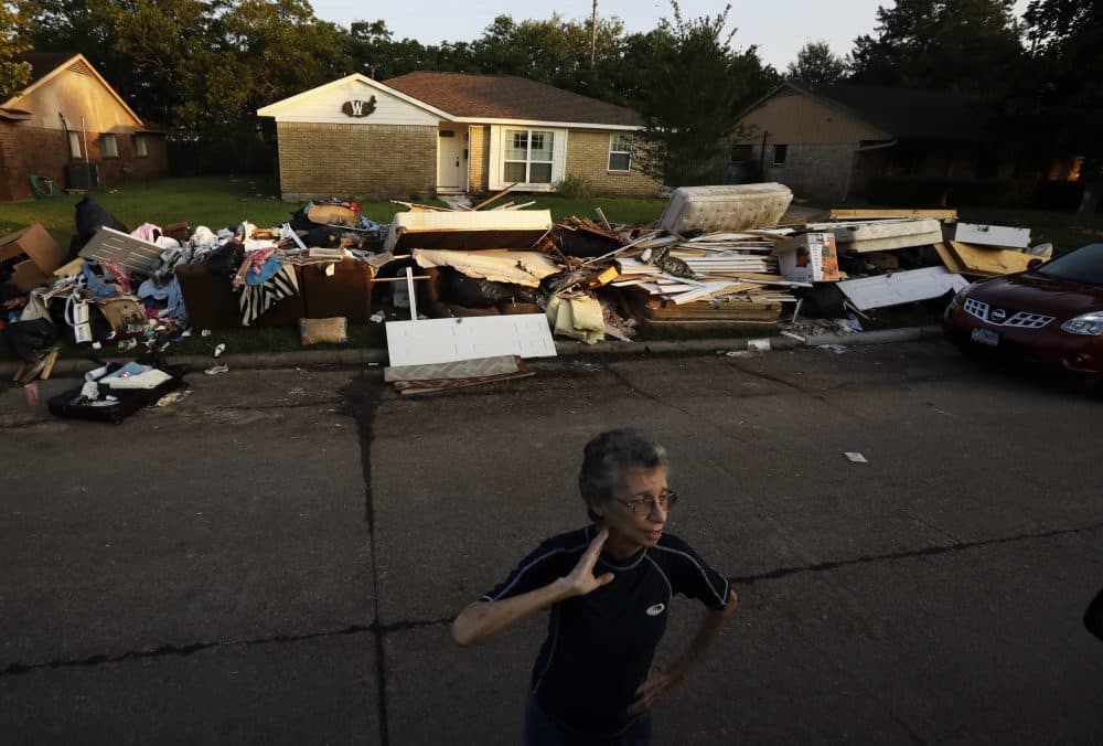 Joan Finmore looks out as she takes a break from sorting items at a friend's flooded home Saturday, Sept. 2, 2017, in Houston. Thousands of people have been displaced by torrential rains and catastrophic flooding since Harvey slammed into Southeast Texas last Friday. (AP Photo/Gregory Bull)