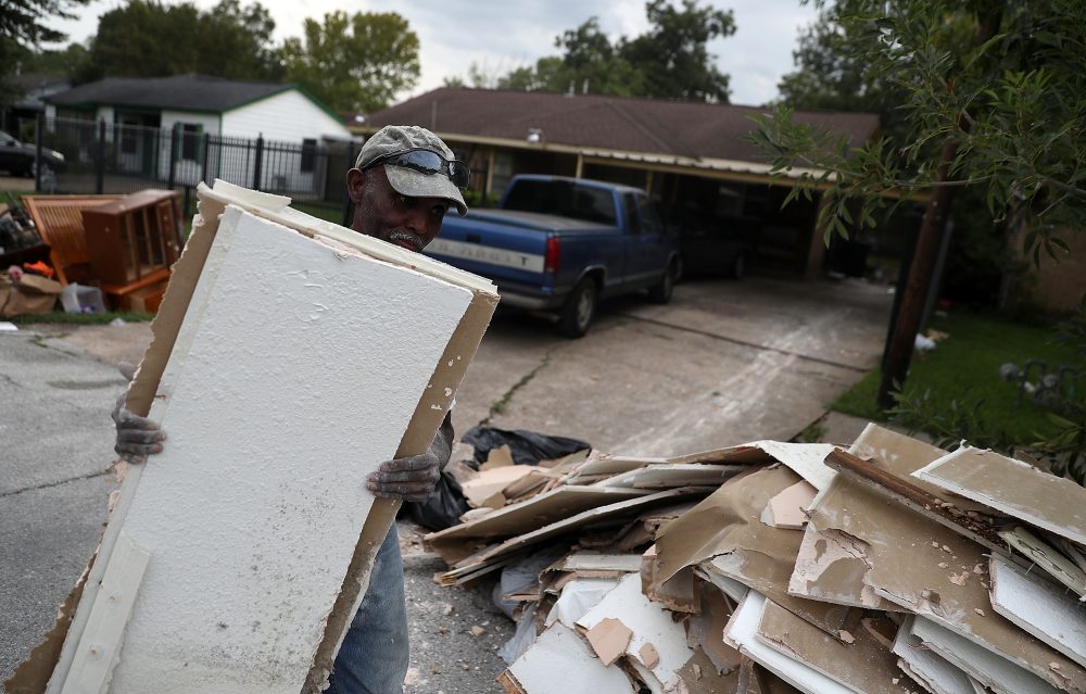 Rufus Lee of Top to Bottom Home Renovations carries moldy drywall out of a flood damaged home that he is cleaning out on Sept. 5, 2017, in Houston. (Justin Sullivan/Getty Images)