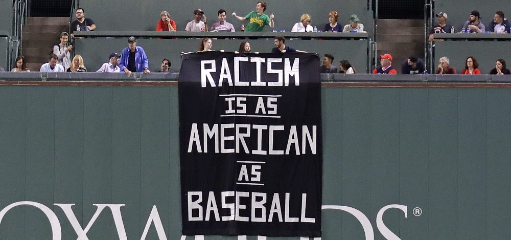 A banner is unfurled over the left field wall during the fourth inning of a baseball game between the Boston Red Sox and Oakland Athletics at Fenway Park in Boston on Wednesday. (Charles Krupa/AP)