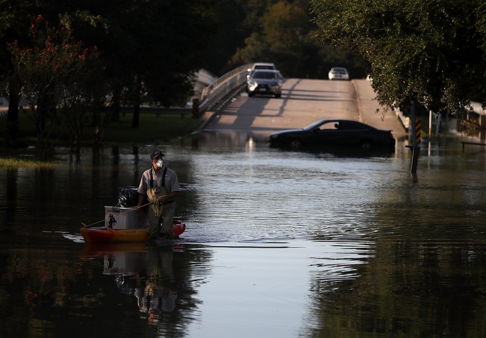 A resident pulls personal belongings on a kayak as he wades through floodwaters on Sept. 6, 2017 in Houston, Texas. (Justin Sullivan/Getty Images)