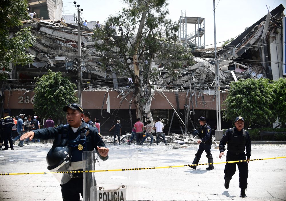 Police officers cordon the area off after a building collapsed during a quake in Mexico City on Sept. 19, 2017. A powerful earthquake shook Mexico City on Tuesday, causing panic among the megalopolis' 20 million inhabitants on the 32nd anniversary of a devastating 1985 quake. (Ronaldo Schemidt/AFP/Getty Images)