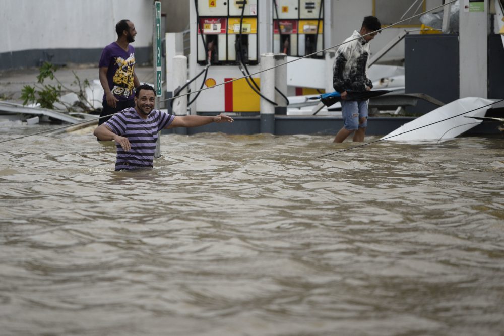 People examine a gas station flooded and damaged by the impact of the strongest hurricane to hit Puerto Rico in more than 80 years. (Carlos Giusti/AP)