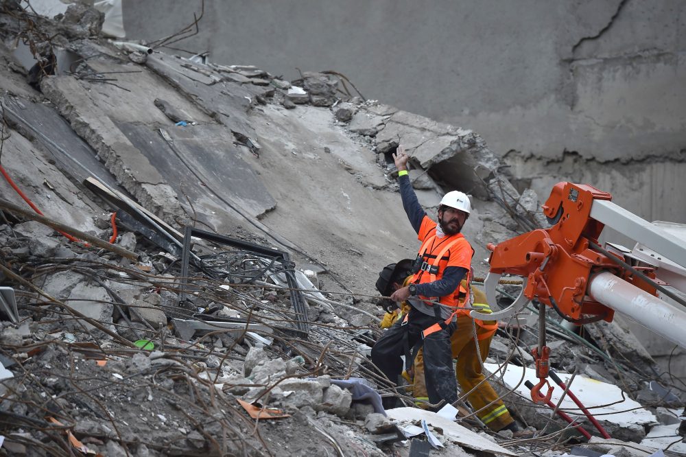 A rescuer and a firefighter search for survivors in a flattened building in Mexico City on Sept. 21, 2017, as the search for survivors continues two days after a strong quake hit Central Mexico. (Yuri Cortez/AFP/Getty Images)
