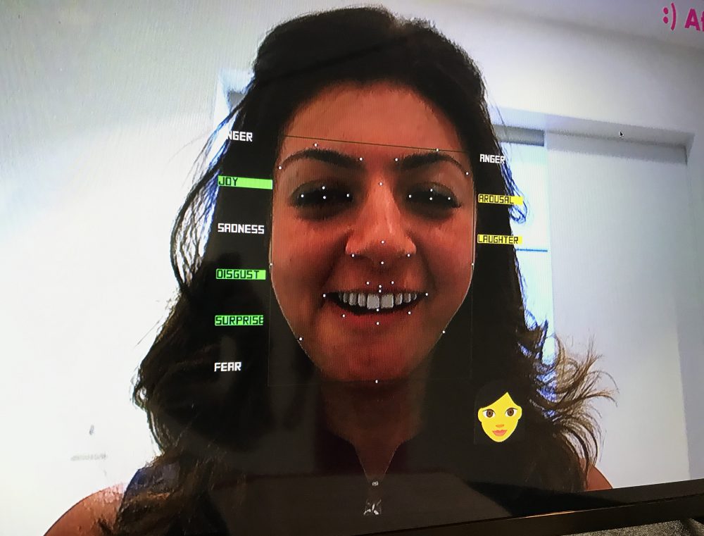Rana el Kaliouby tests out her company's 'emotion AI' technology. The data points on the left offer analysis of her facial expressions, while the data points on the right refer to her voice and tone. (Asma Khalid/WBUR)