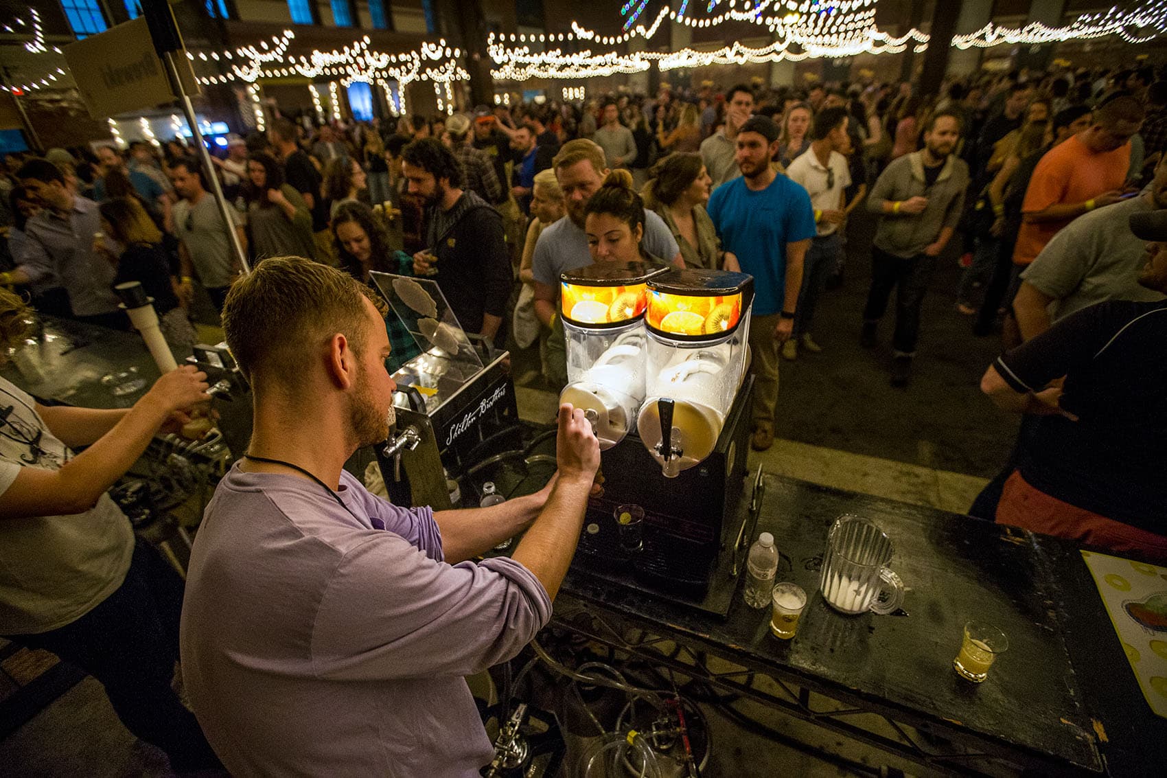 Hundreds gathered for the Copenhagen Beer Festival at the SoWa Power Station in the South End Friday and Saturday. Here, William Blennow of Sweden's Omnipollo Brewing tops a beer with frozen lemonade IPA as he serves a line that stretches to the other end of the building. (Jesse Costa/WBUR)