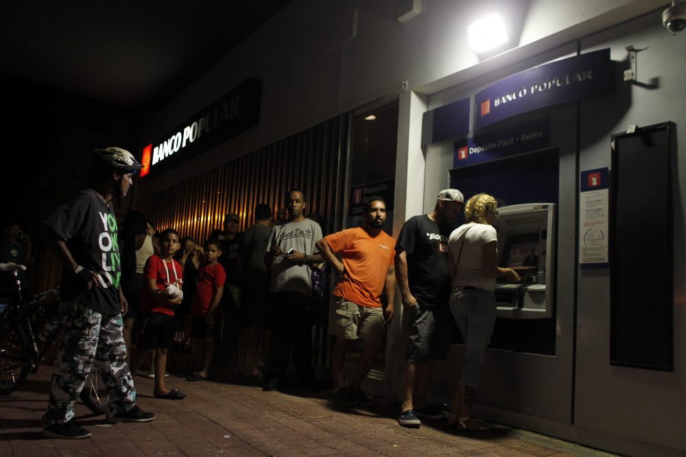 People wait in line at an ATM to withdraw money in San Juan, Puerto Rico, on Sept. 25, 2017, where a 7 p.m. to 6 a.m. curfew has been imposed following Hurricane Maria's impact on the island. (Ricardo Arduengo/AFP/Getty Images)