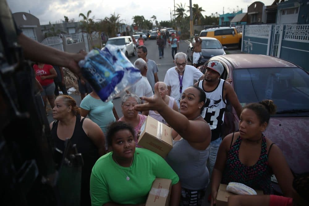Hurricane survivors receive food and water being given out by volunteers and municipal police as they deal with the aftermath of Hurricane Maria on Sept. 28, 2017, in Toa Baja, Puerto Rico. (Joe Raedle/Getty Images)