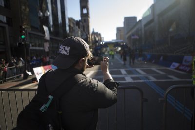 Brian Marcou takes a photo of the finish lne at Exeter St. (Jesse Costa/WBUR)