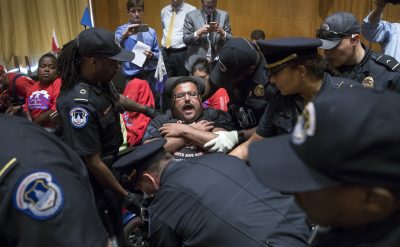 Activists opposed to the GOP's Graham-Cassidy health care repeal bill, many with disabilities, are removed by U.S. Capitol Police after disrupting a Senate Finance Committee hearing on the last-ditch GOP push to overhaul the nation's health care system, on Capitol Hill in Washington, Monday, Sept. 25. (J. Scott Applewhite/AP)