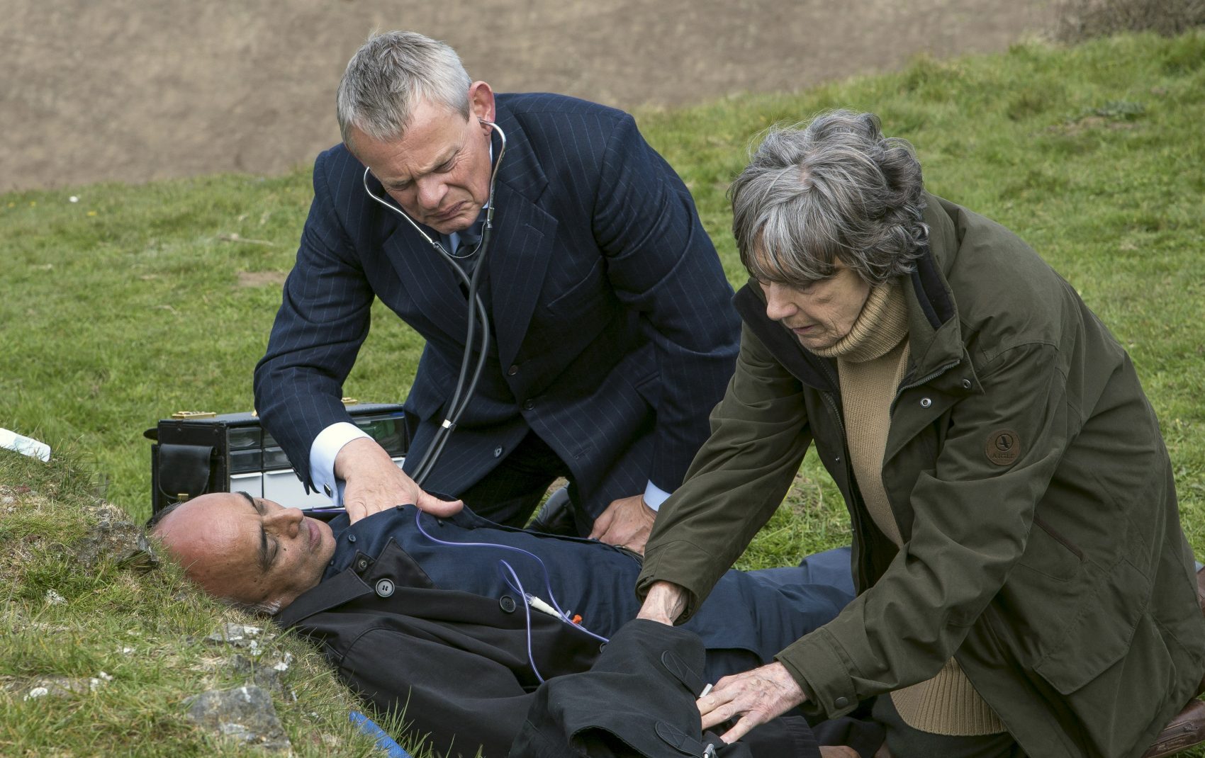 Martin Clunes as &quot;Doc Martin&quot; tends to Art Malik as a visitor to Portwenn. Eileen Atkins plays his aunt. (Courtesy of Acorn TV)