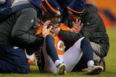 Former Broncos safety David Bruton is attended to by trainers after a play that would force him out of a 2014 game against the Raiders with a reported concussion. (Doug Pensinger/Getty Images)