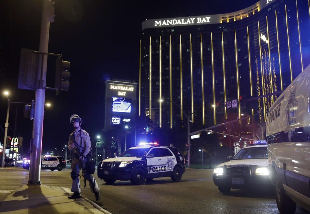 Police officers stand along the Las Vegas Strip on Sunday night. The suspect, Stephen Paddock, 64, a resident of the Las Vegas area, is dead after police confronted him on the 32nd floor of the Mandalay Bay Hotel and Casino. (John Locher/AP)
