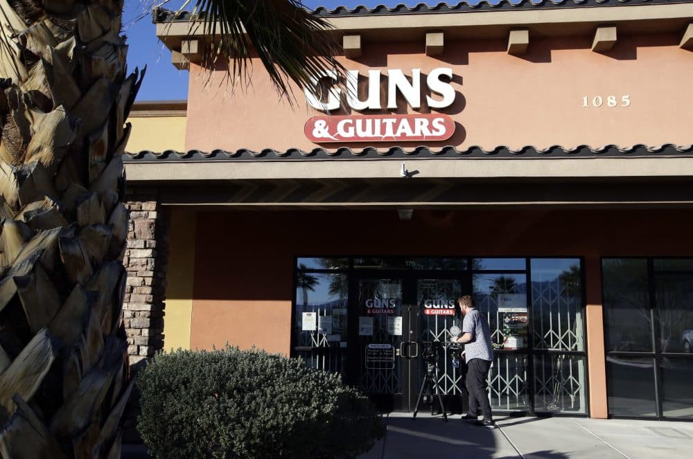 A member of the media takes video footage of the front of the Guns & Guitars store in Mesquite, Nev., Monday, Oct. 2, 2017. The store's general manager Christopher Sullivan said in a statement Monday that Stephen Craig Paddock showed no signs of being unfit to buy guns. (Chris Carlson/AP)