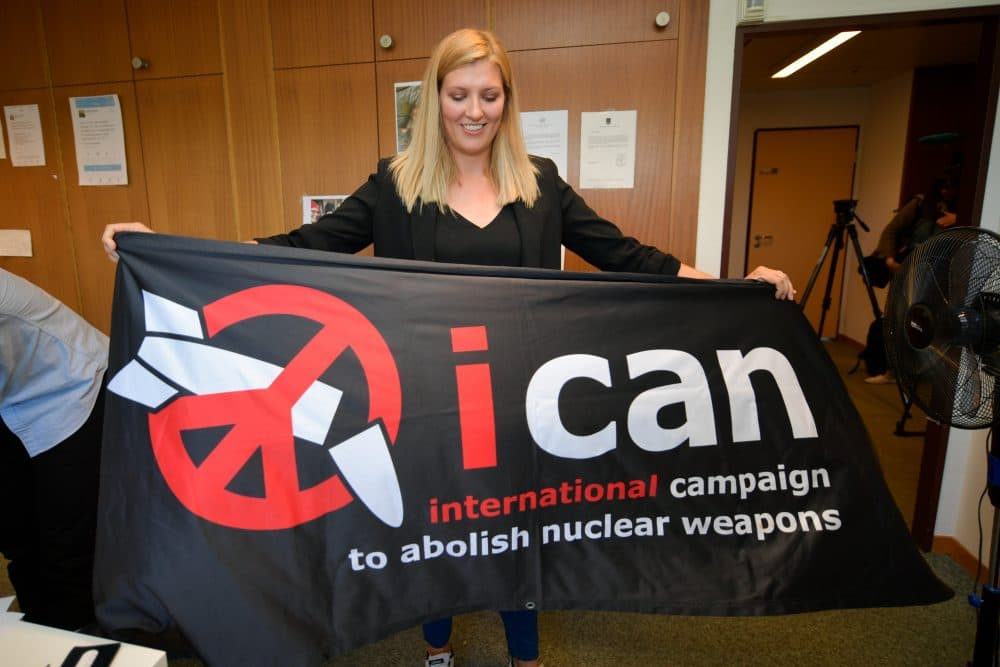 Nuclear disarmament group ICAN executive director Beatrice Fihn holds a banner with their logo after ICAN won the Nobel Peace Prize for its decade-long campaign to rid the world of the atomic bomb as nuclear-fuelled crises swirl over North Korea and Iran, on Oct. 6, 2017, in Geneva. (Fabrice Coffrini/AFP/Getty Images)