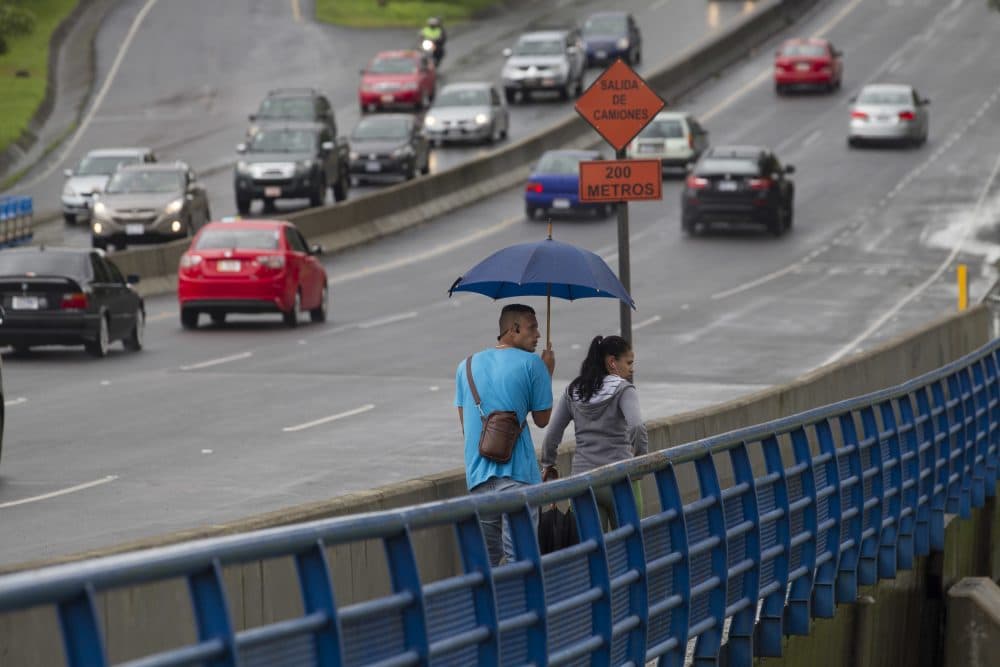 A couple cross a bridge over the Maria Aguilar river on the outskirts of San Jose, Costa Rica, Thursday, Oct. 5, 2017. Tropical Storm Nate formed off the coast of Nicaragua on Thursday and was being blamed for at least 17 deaths in Central America as it spun north toward a potential landfall on the U.S. Gulf Coast as a hurricane over the weekend. (Moises Castillo/AP)