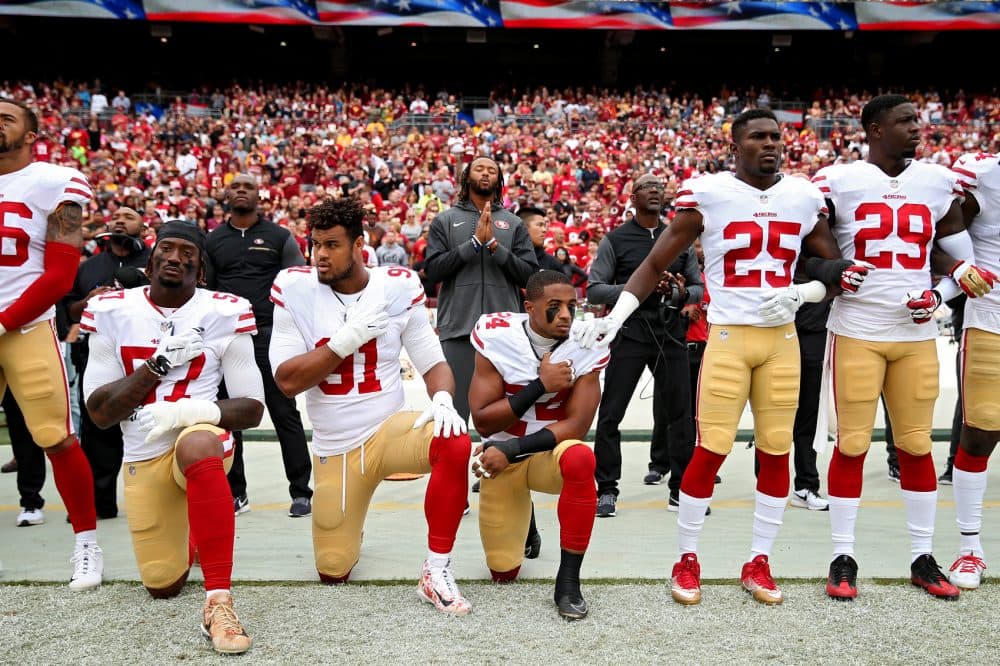 K'Waun Williams, Arik Armstead and Eli Harold of the San Francisco 49ers kneel while holding their hands over their chest during the U.S. national anthem before playing against the Washington Redskins at FedExField on Oct. 15, 2017, in Landover, Md. (Patrick Smith/Getty Images)