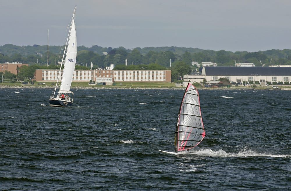 A windsurfer and people aboard a sailboat enjoy the strong winds of Narragansett Bay off the coast of Newport, R.I. (Stew Milne/AP)