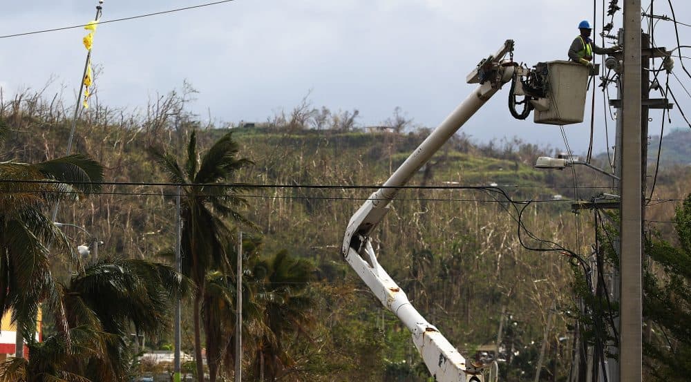 A worker repairs power lines about two weeks after Hurricane Maria swept through the island on Oct. 5, 2017 in San Isidro, Puerto Rico. (Mario Tama/Getty Images)